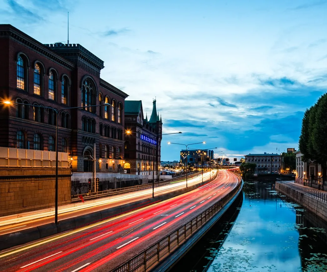 Dusk cityscape with light trails along a waterfront