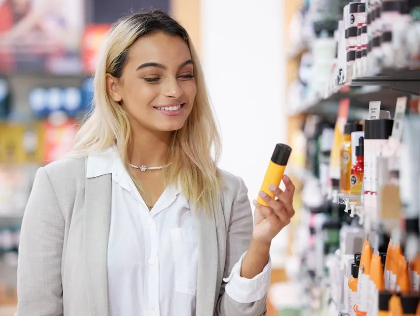 Shopper examining a consumer packaged goods product on a retail shelf