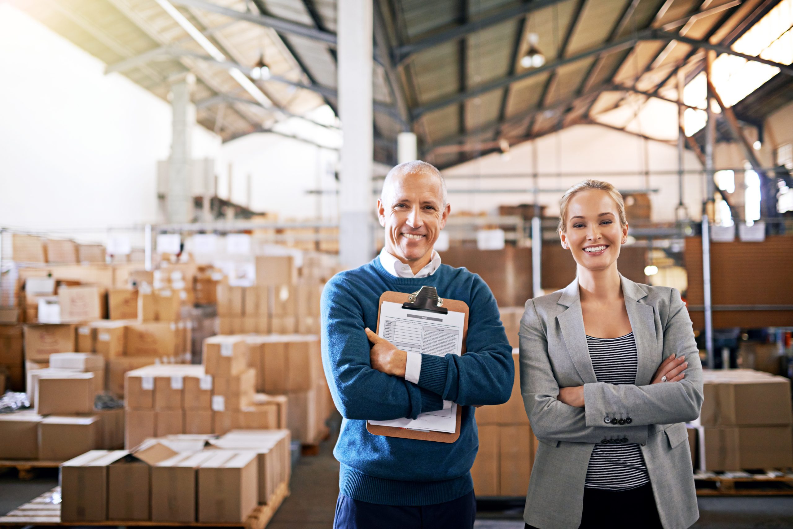 Portrait of two mangers standing in a large warehouse.